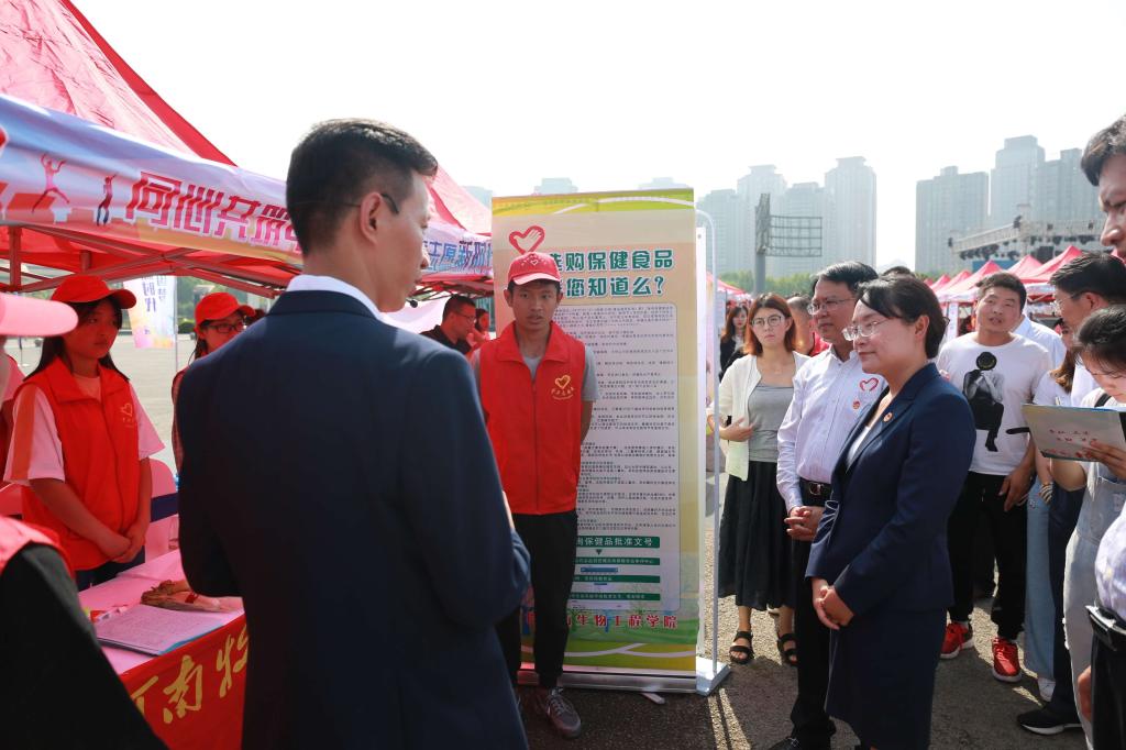 省青联副主席张楠向团省委书记王艺介绍五大联赛“食品安全进社区”项目